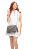 Model holding dove colored crocheted shoulder bag with cotton lining, snap closure, leather strap & tassel