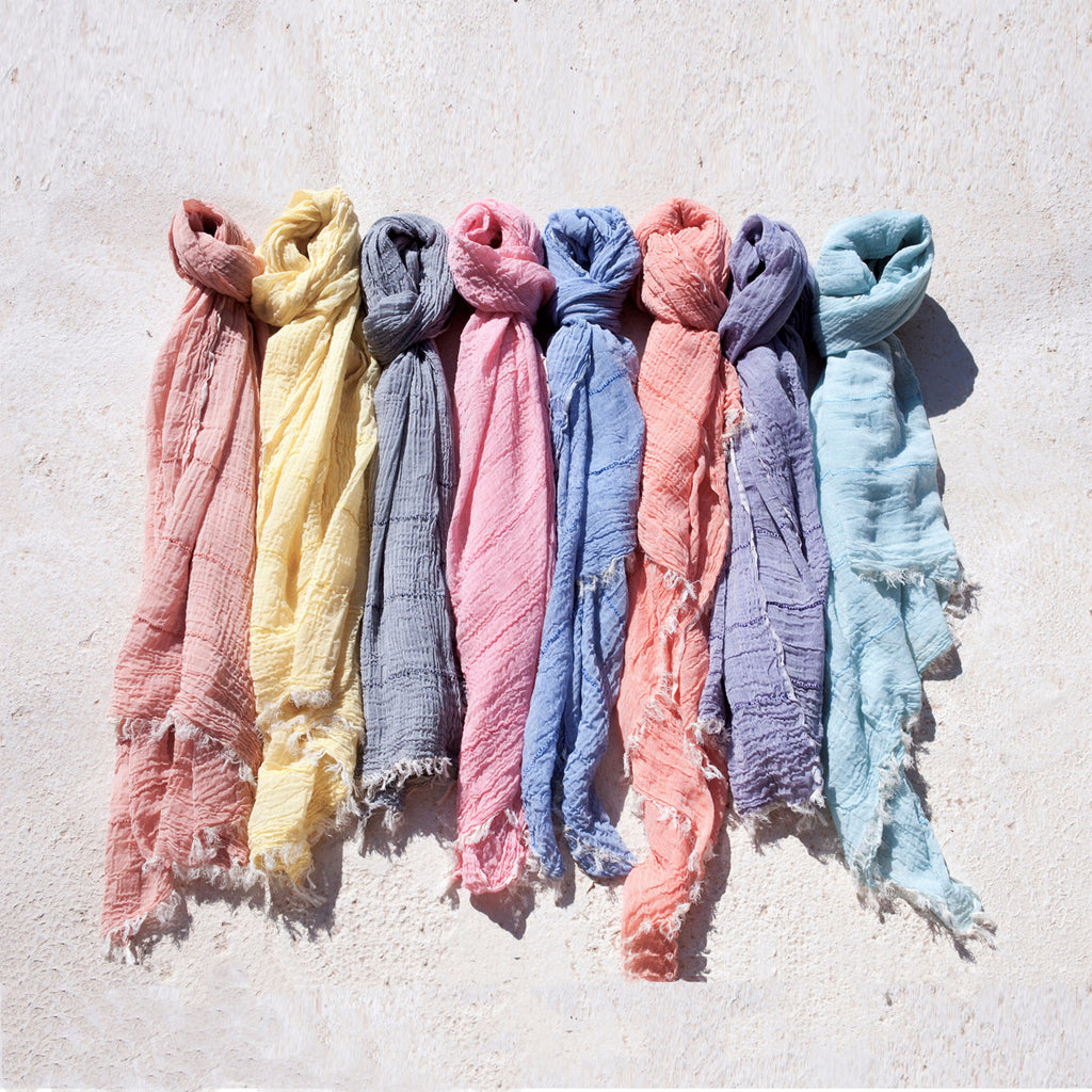 Collection of colorful knotted scarves in a row
