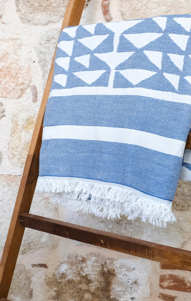 Hand woven Turkish cotton throw in marine and white folded on a rack