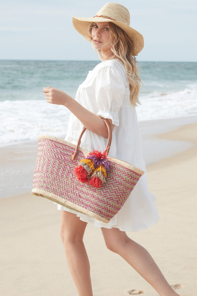 Model on beach with our Madrigal tote in Pink