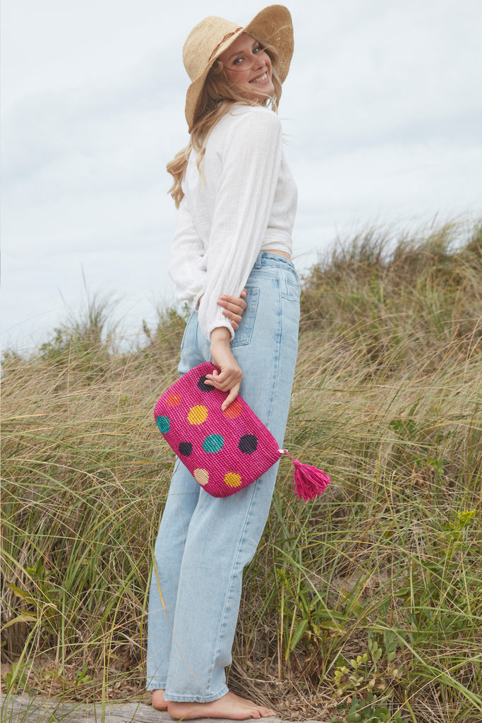 Model in front of beachy grass holding Maria in Pink