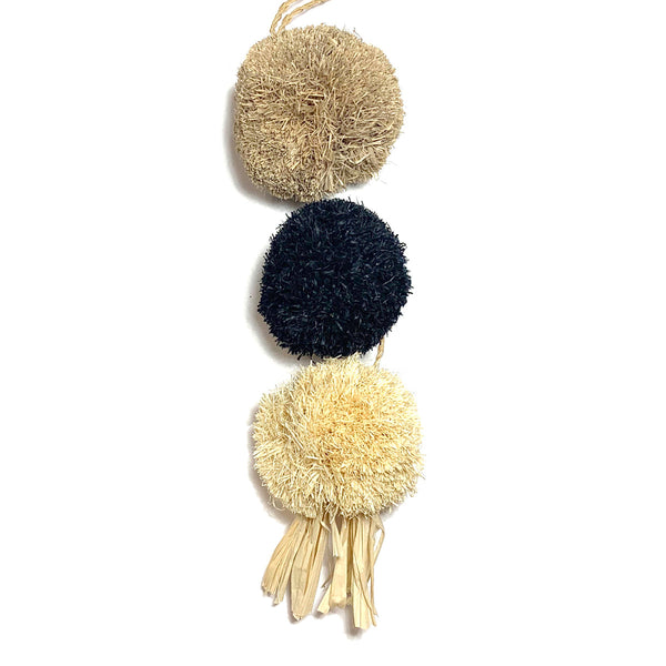 Handmade raffia triple pom pom chain with sand, navy, and natural colored poms