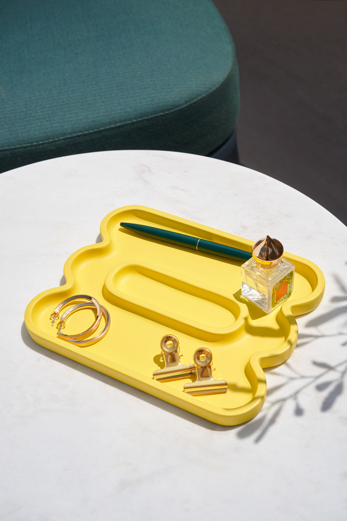 Yellow colored catchall tray with props in it