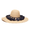 Wide brim braided raffia sun hat with a ring of navy colored tassels