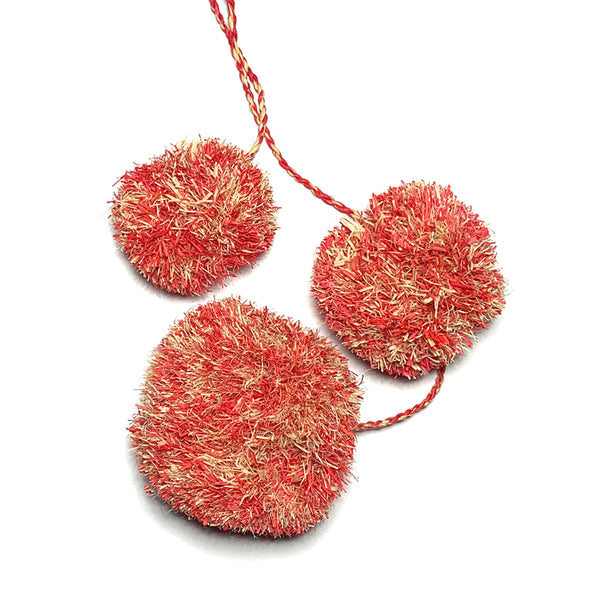 Mottled coral and natural colored pompoms as used on our Caracas tote.