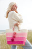 Model holding three color pink sisal basket tote with removable poms & leather handles