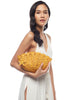Model holding the Shelley clutch in Sunflower on a white background