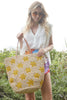 Model holding our Soleil tote with wildflowers behind her