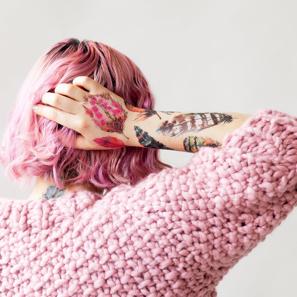 Model in pink sweater with Flying Colors tattoos