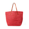 Coral colored crocheted carryall with snap closure, cotton lining & leather straps